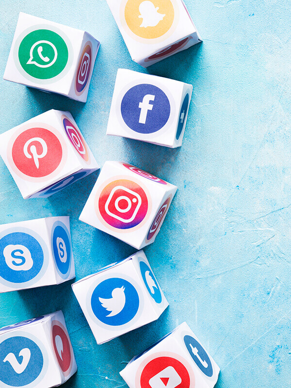 gomila kockica sa odštampanim logotipima socijalnih mreža na stranicama, postavljenih na svetlo plavoj pozadini