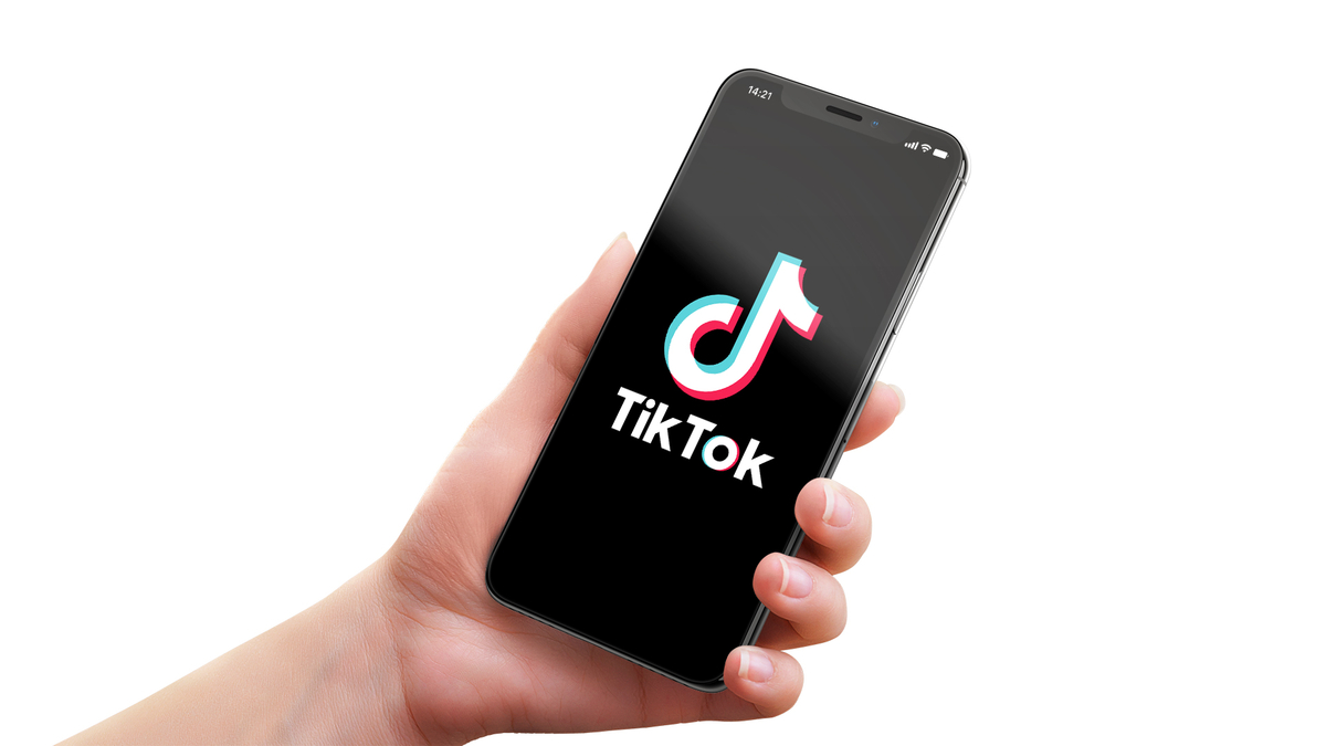 tiktok ikonica preko crnog ekrana na mobilnom telefonu u ruci