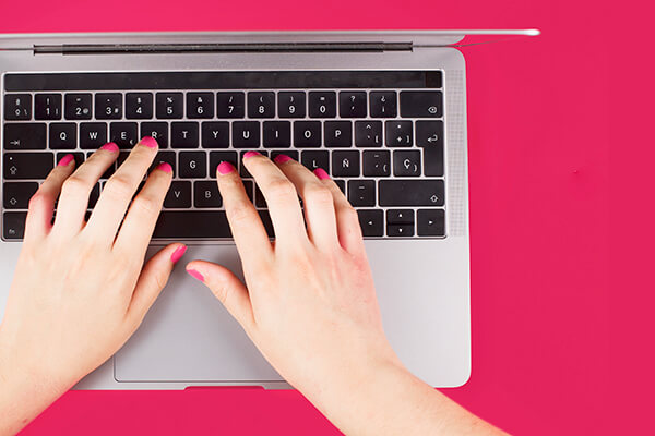 izlakirani ženski prsti kucaju po tastaturi laptopa